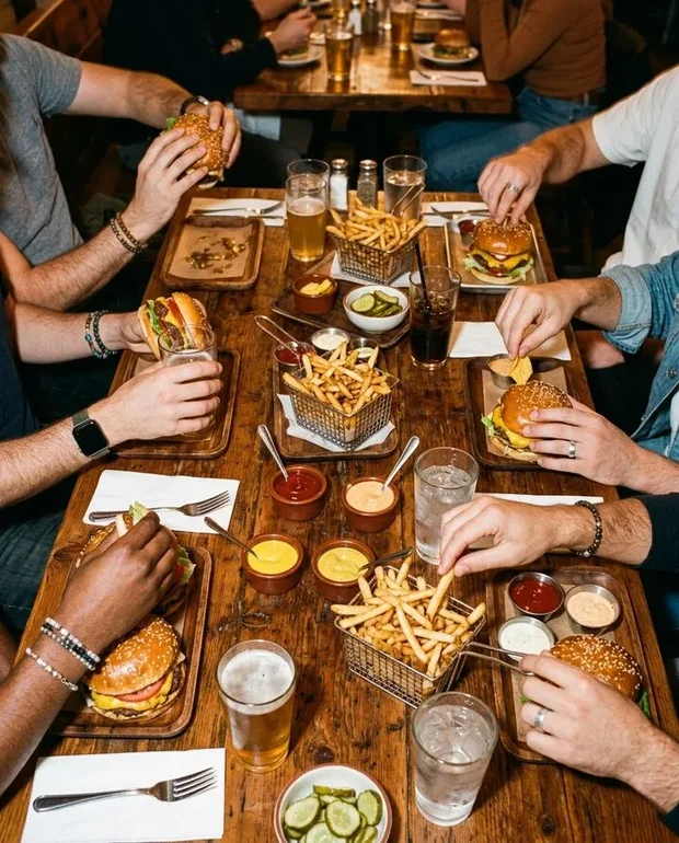 Tafel vol burgers, friet en sauzen van bovenaf