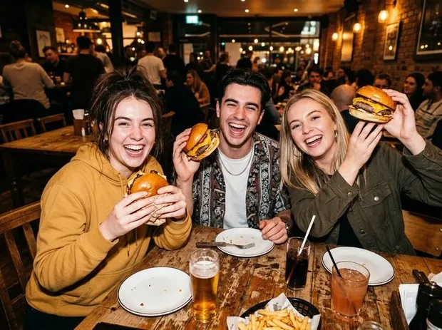 Drie vrienden houden lachend hun burgers omhoog
