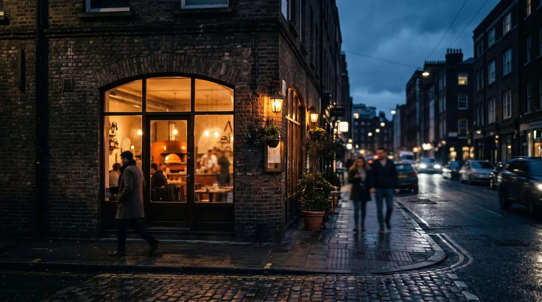 Straatbeeld met de verlichte gevel van een pizzeria in de avond